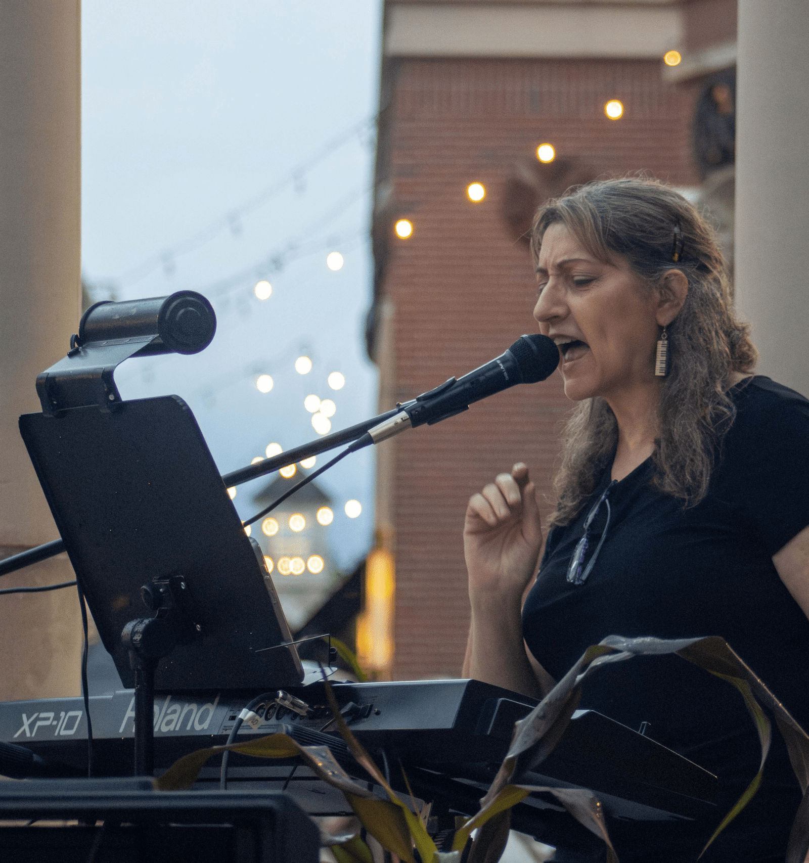 Woman performing at an outdoor concert.