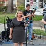 Woman performing at an outdoor concert.