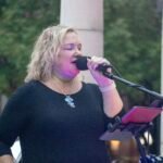 Woman performing at an outdoor concert.