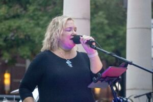 Woman performing at an outdoor concert.