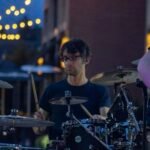 Man performing at an outdoor concert at night.