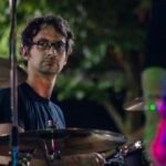 Man performing at an outdoor concert at night.