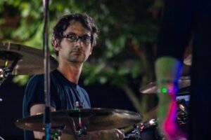 Man performing at an outdoor concert at night.