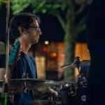 Man performing at an outdoor concert at night.