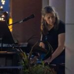 Woman performing at an outdoor concert at night.