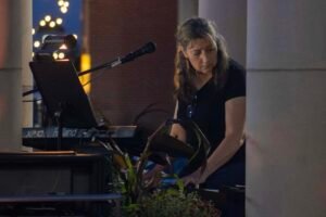 Woman performing at an outdoor concert at night.