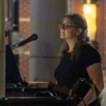 Woman performing at an outdoor concert.