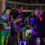 Musicians performing at a concert at night.