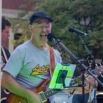 Man performing at an outdoor concert.