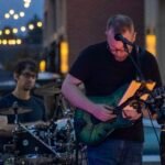 Man performing at an outdoor concert at night.