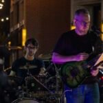 Musicians performing at a concert at night.