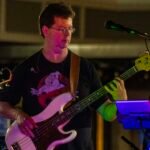 Man performing at an outdoor concert at night.