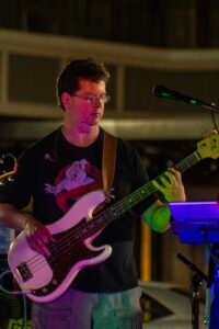 Man performing at an outdoor concert at night.